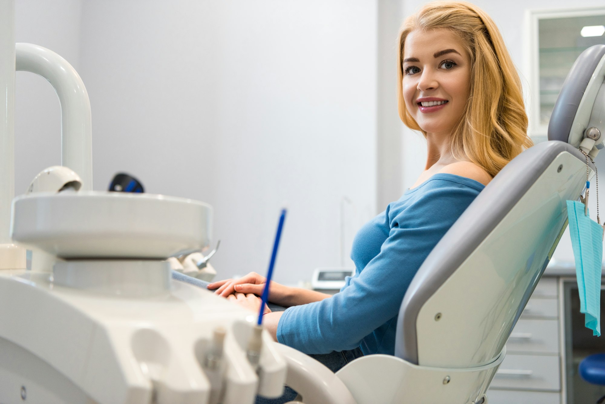 Blonde woman smiling, seated comfortably in dental chair at VZ Dentistry.